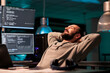 © DC Studio - Happy relaxed developer sitting laid back on chair, feeling pleased about software development work in office. Enjoying server programming success late at night, server code html script.