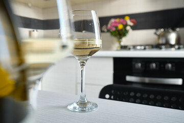 Two glasses of white wine on the kitchen table. Celebrate and enjoy the moment. Tasting of alcoholic beverages. Glass of wine close-up