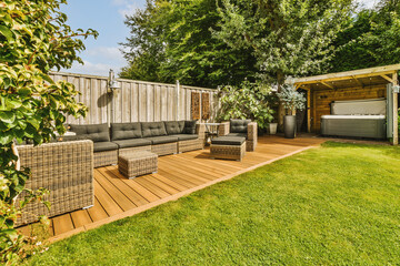 Neat paved patio with sitting area and small garden near wooden fence