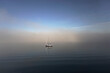 St. Margarets Bay, Nova Scotia, Canada: A solitary sailboat anchored in the bay shrouded in an early-morning mist.