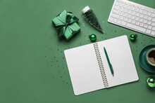 Notebook With Cup Of Coffee, Gift, Christmas Decor And Computer Keyboard On Green Background