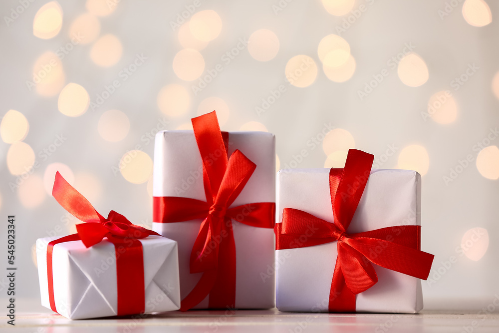 Christmas gifts on table against blurred lights
