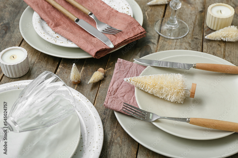 Beautiful table setting with Christmas trees on wooden background, closeup
