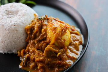 Wall Mural - Egg roast curry or Mutta roast gravy hot and spicy dish popular spicy Kerala food with puttu appam on wooden background Tamil Nadu South India.	