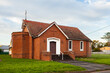 © Austockphoto - Brick church building at dusk with doors shut
