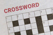Crossword puzzle in a local newspaper for readers to challenge themselves mentally by solving cryptic word clues. A crossword puzzle in the papers with name or title printed at the top. Closeup view.