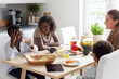 © Johnér - Family sitting at table and eating breakfast