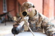 Military man with a weapon aiming through the scope