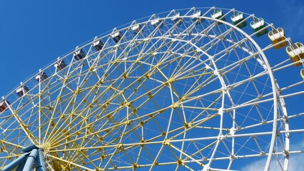 Wall Mural - cabins of a rotating Ferris wheel against the background of a blue sky. 