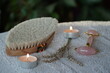 spa still life with horsehair dry brush, tea light candles, pink jade roller, dried lavenders, towel