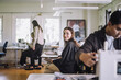 © Maskot - Portrait of smiling female fashion designer sitting at workshop