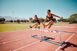 Sport, jump and women runner doing hurdles on stadium track, athlete running race and fitness training outdoor. Practice, workout and sports, speed and agility for exercise and cardio motivation.