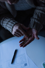 Wall Mural - partial view of man counting coins near blurred payment bills during power blackout.