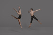 © master1305 - Young man and woman, ballet dancers performing isolated over dark grey studio background. Expressing talent