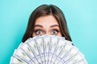 Closeup photo of young excited positive cute lady hiding face much cash dollars playful childish rich successful business isolated on aquamarine color background