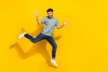 Wall Mural - Full body portrait of satisfied glad person jumping raise hands empty space isolated on yellow color background