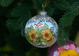 made of glass painted handmade christmas decoration hanging on a christmas tree before new year