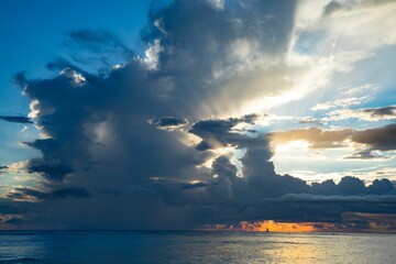 Sticker - Beautiful sky under a cloudy sky with a small sailboat swimming against the sunset