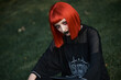 © Teodor Lazarev - Young urban goth girl with a red hair wig posing outdoors, representing alternative subculture