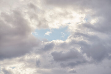 Wall Mural - blue sky gap in the middle of white rain clouds