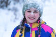 Cute happy smiling little girl, whose face is covered in snow, is enjoying winter