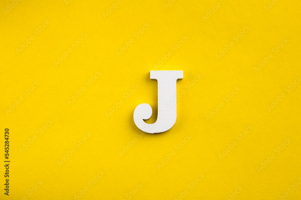 letter J uppercase - white wood letter on yellow color background Stock ...