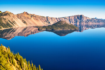 Wall Mural - view of crater lake with perfect reflections on a calm summer morning.