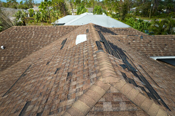 Poster - Damaged house roof with missing shingles after hurricane Ian in Florida. Consequences of natural disaster