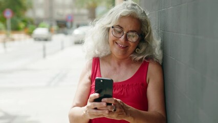 Poster - Middle age grey-haired woman smiling confident using smartphone at street