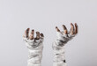 Mummy hands wrapped in a bandage isolated on gray background. Halloween concept