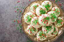 Soft Buttery Anise Flavored Italian Cookies Are Dipped In A Creamy Glaze, Topped With Colorful Sprinkles Closeup In The Plate On The Table. Horizontal Top View From Above