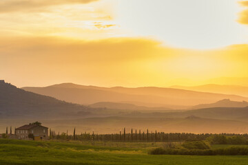 Canvas Print - Farmhouse on the fields in the evening light over the valley