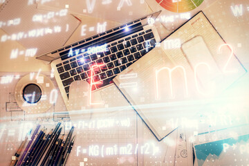 Poster - Physics and math theme hologram with formula drawings over computer on the desktop background. Top view. Multi exposure. Concept of education.