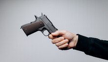 Attack And Defense. Close Up Of Male Hand Giving A Pistol.