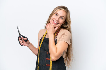 Wall Mural - Young blonde seamstress woman isolated on white background happy and smiling