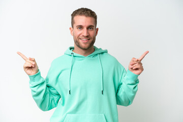 Canvas Print - Young handsome caucasian man isolated on white background pointing finger to the laterals and happy