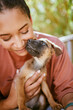 © S Fanti/peopleimages.com - Love, care and pet dog with black woman in garden for bond, affection and happiness together. Wellness, calm and healthy adoption puppy bonding embrace with happy girl owner in backyard.