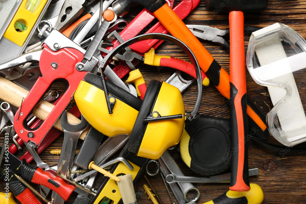 Hearing protectors with builder's tools on dark wooden background