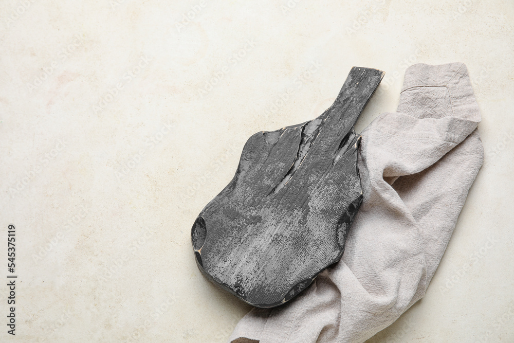 Black wooden cutting board with napkin on white background