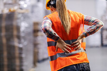 A Storage Worker Having Back Pain And Holding Spine.