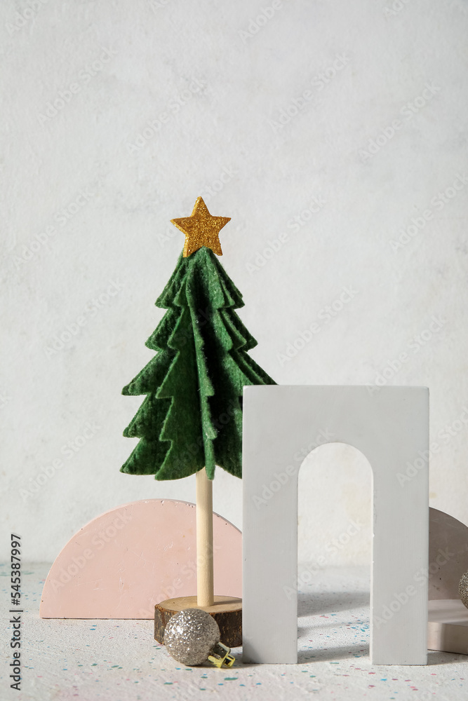 Decorative Christmas tree with podiums and balls on light background