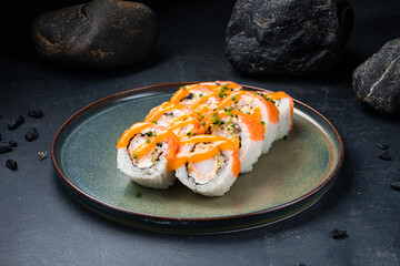 Wall Mural - Japanese Philadelphia rolls with shrimp, salmon, avocado, Philadelphia cheese, nori, rice with mango sauce on a plate.