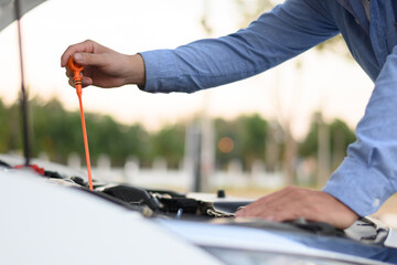 man checking engine oil on the way