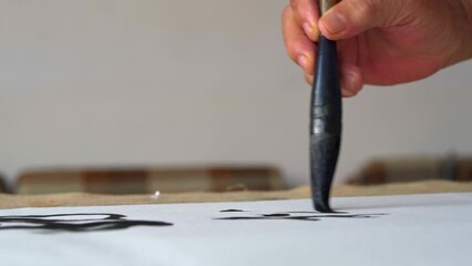 Wall Mural - an old chinese calligrapher is writing calligraphy characters, creating calligraphy works