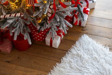 Wall Mural - Beautiful Christmas gift boxes on floor near fir tree in room.