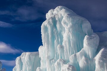 Wall Mural - Frozen geyser forming a majestic ice sculpture against the blue sky
