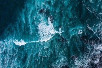 Wall Mural - the turquoise ocean breaks in white foamy waves on the black beach