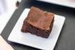 Selective focus shot of a chocolate brownie on a white plate