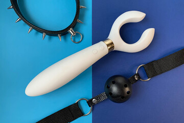 Wall Mural - Sex shop assortment. White vibrator,  collar, gag on blue background. BDSM toys