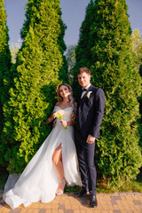 Wall Mural - happy newlyweds. groom and bride in traditional wedding clothes in park